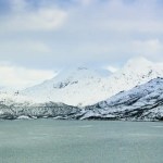 Utsikt over hav og hvite fjell